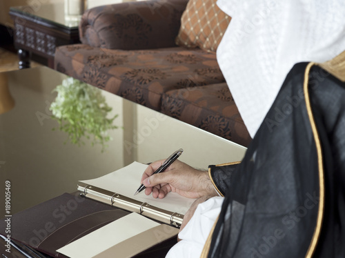 Saudi Arabian Man Hand Writing on A Notebook photo