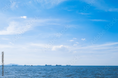 Landscape of sea sun and ship under cloudy blue sky. Summer holiday relax background with copy space.
