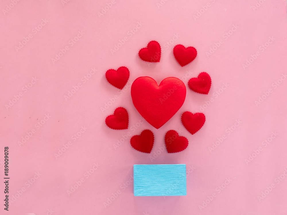 red heart and gift box with pink background, flat lay