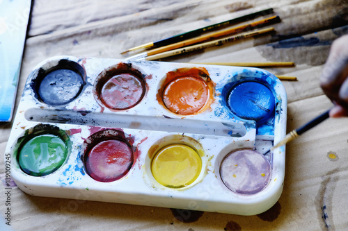 Kids Paints, brushes and palette on the colorful Color. The workplace of the artist.