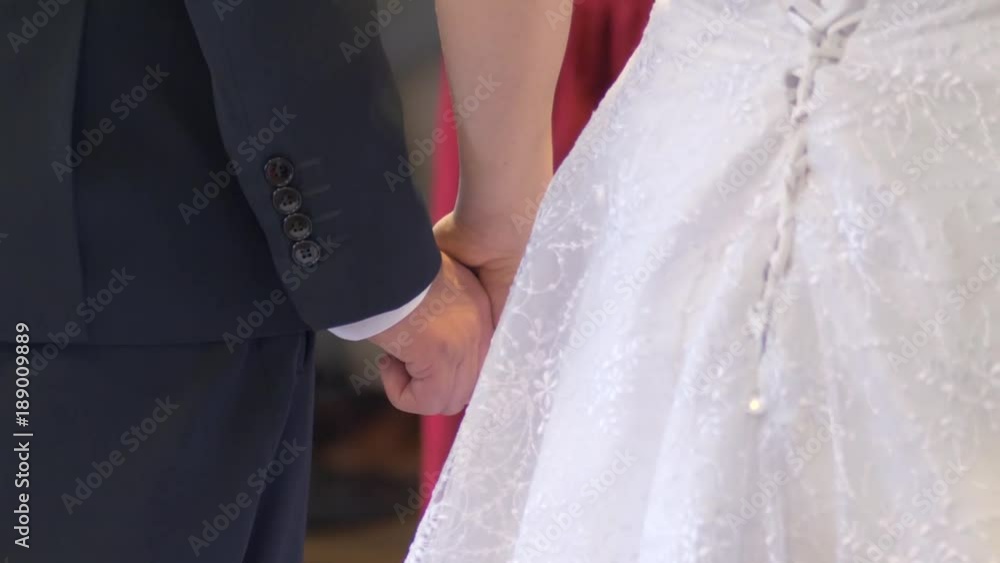Wedding couple holding hands during ceremony Wedding couple holding hands during ceremony