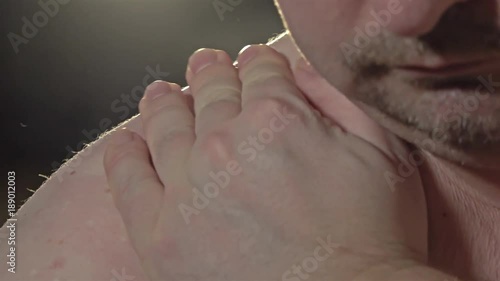 Close up of man massaging his shoulder and neck photo