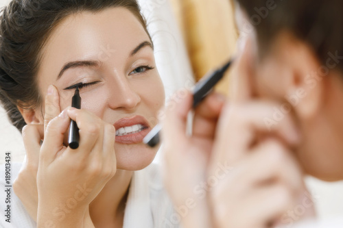 Woman is disappointed with her skill of applying makeup photo