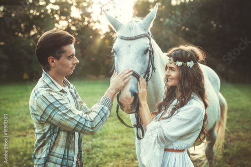 Young happy couple and beautiful horse
