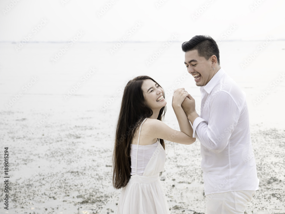 Young Asian couple in love on the beach.