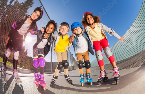 Happy little roller-skaters having fun outdoors