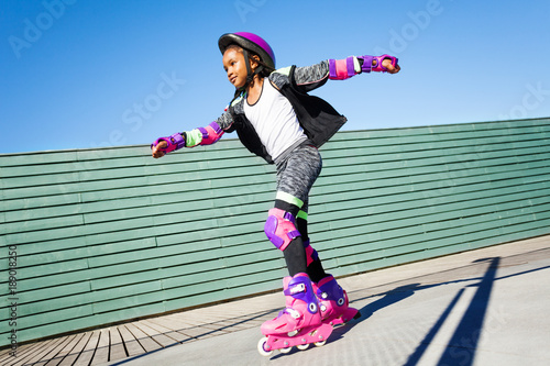 African girl riding fast at outdoor rollerdrom