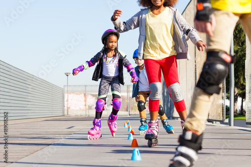 Fototapeta Naklejka Na Ścianę i Meble -  Kids learning to slalom skate with inline skates