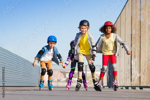 Boys and girls rollerblading at stadium outdoors