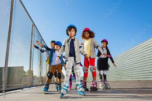 Preteen kids rollerblading outdoors at stadium
