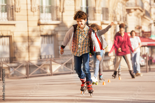 Happy teenage boy roller skating at city side walk