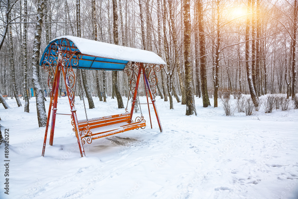 Empty swing in winter time with snow Empty swing in winter time with snow