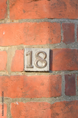 House number 18 sign on wall