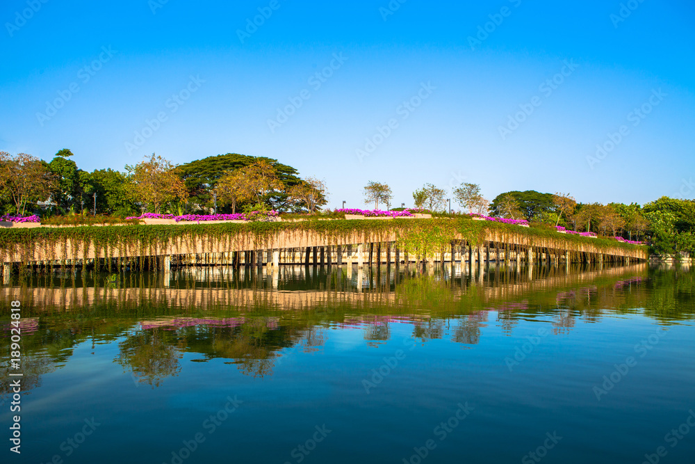 Stone Bridge in a park with lake on blue sky