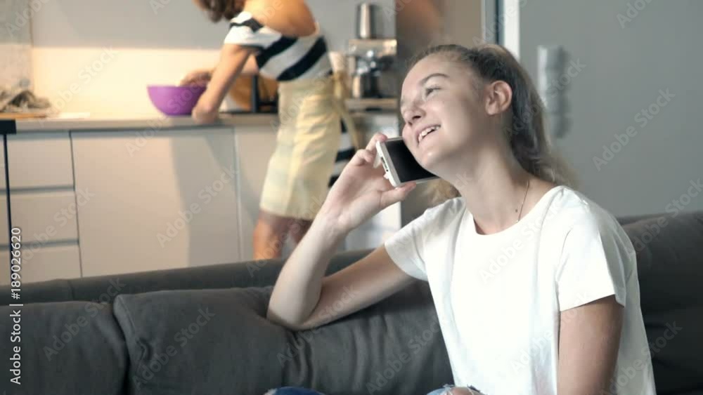 Teenage girl talking on cellphone sitting on sofa at home
Teenage girl talking on cellphone sitting on sofa at home