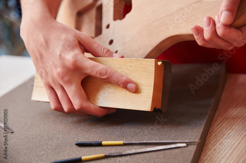 Handwerker schleift Holz mit Schleifpapier
