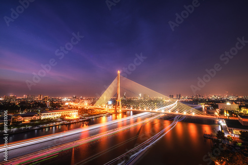 Fototapeta Naklejka Na Ścianę i Meble -  King Rama 8 bridge famous transportation facility in bangkok during night time and light from boat under bridge