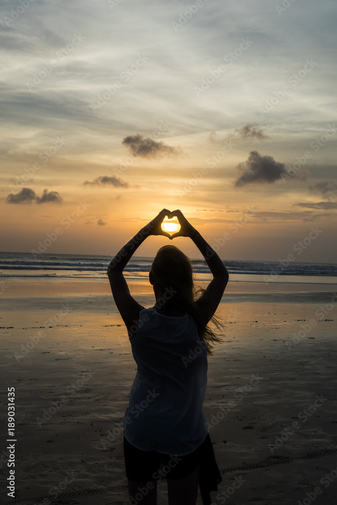 Fototapeta premium Herz mit den Händen vor Sonnenuntergang formen
