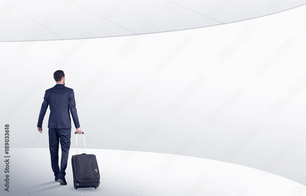 Businessman with suitcase walking in waiting room Businessman with suitcase walking in waiting room