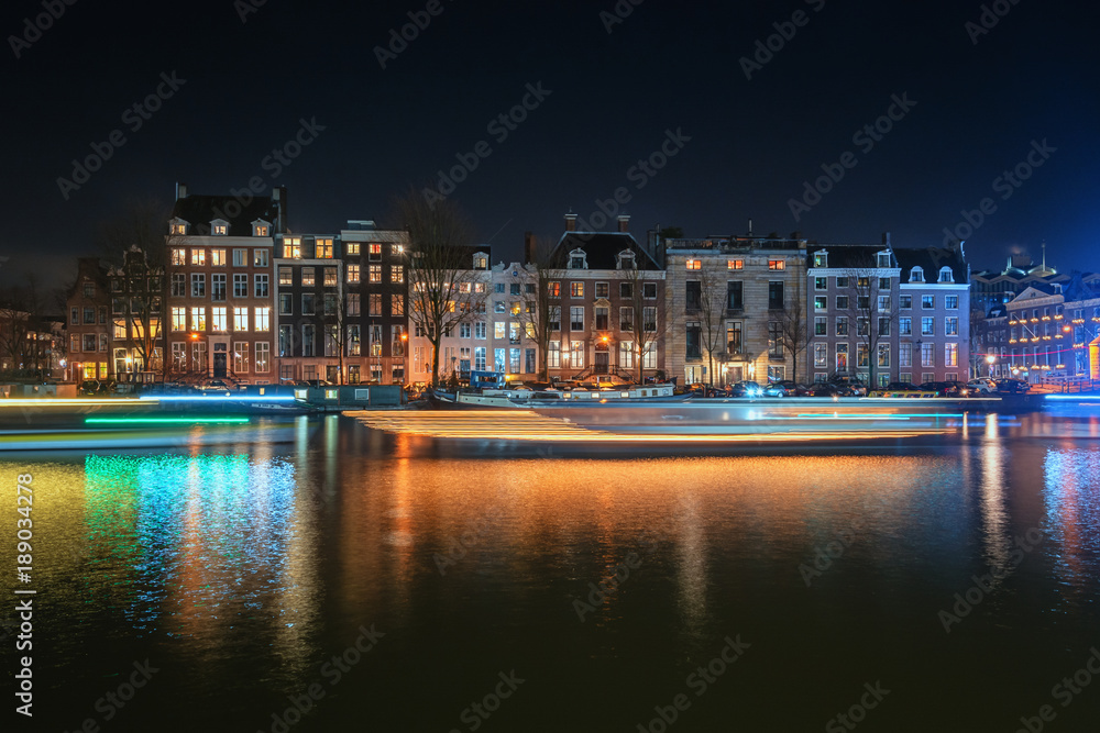 The characteristic canal houses and houseboats along the river Amstel in the old town of Amsterdam