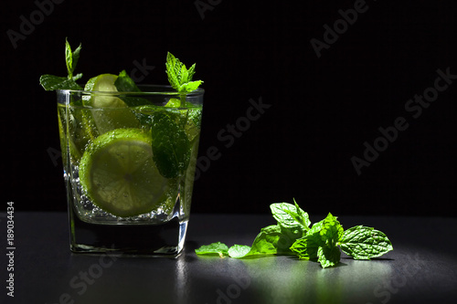 Cocktail with lime , ice and peppermint .