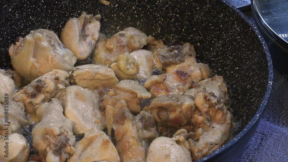 Cooking of chicken pieces in a frying pan closeup Cooking of chicken pieces in a frying pan closeup