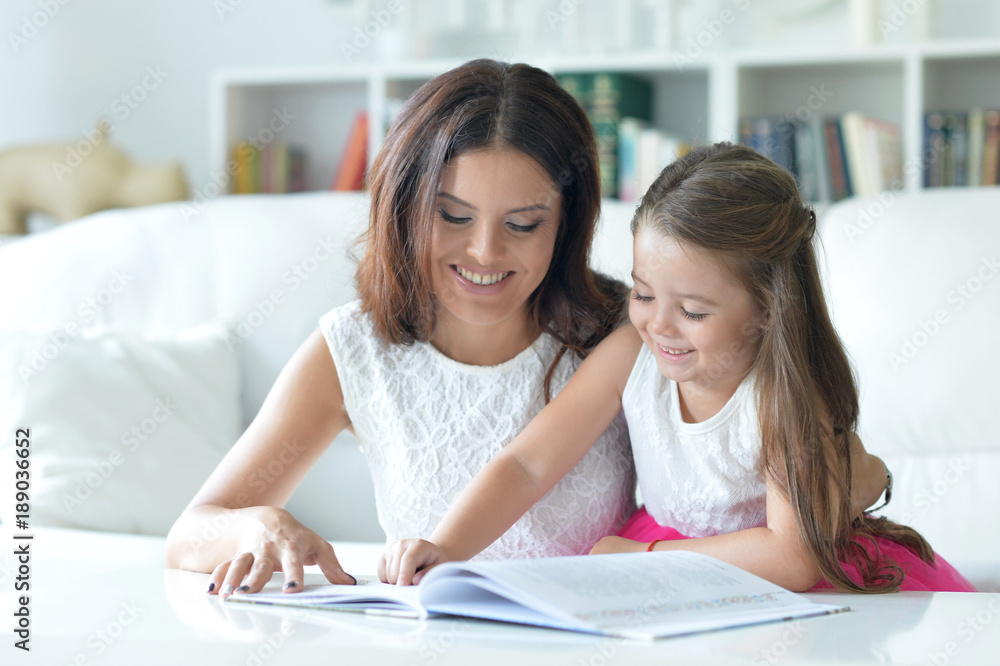 little cute girl reading book with mother little cute girl reading book with mother