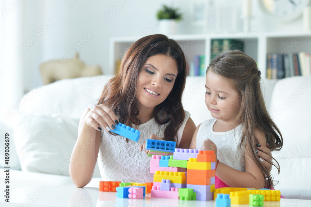 little girl and her mother playing with colorful plastic blocks little girl and her mother playing with colorful plastic blocks