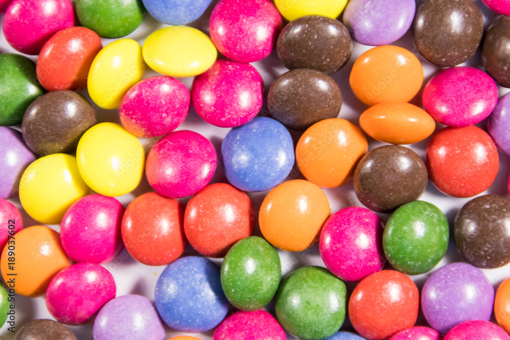 Background of the colorful button shaped candies filled with chocolate Background of the colorful button shaped candies filled with chocolate