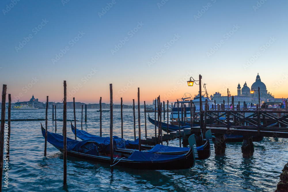Gondolas jetty  at sunset in front of Basilica della Salute. Venice, Italy