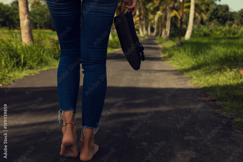 Women's beautiful legs with canvas shoes on the road.