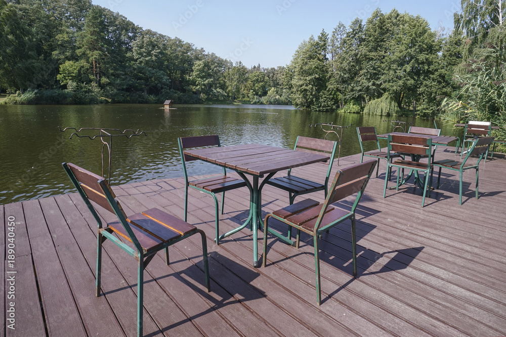 wooden table and chairs of a cafe by lake