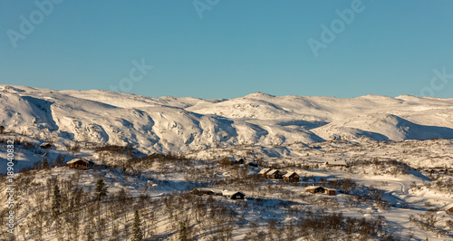 Cabins in the mountains, blue sky, winter and snow in the mountain landscape in Brokke, Setesdal in Norway.