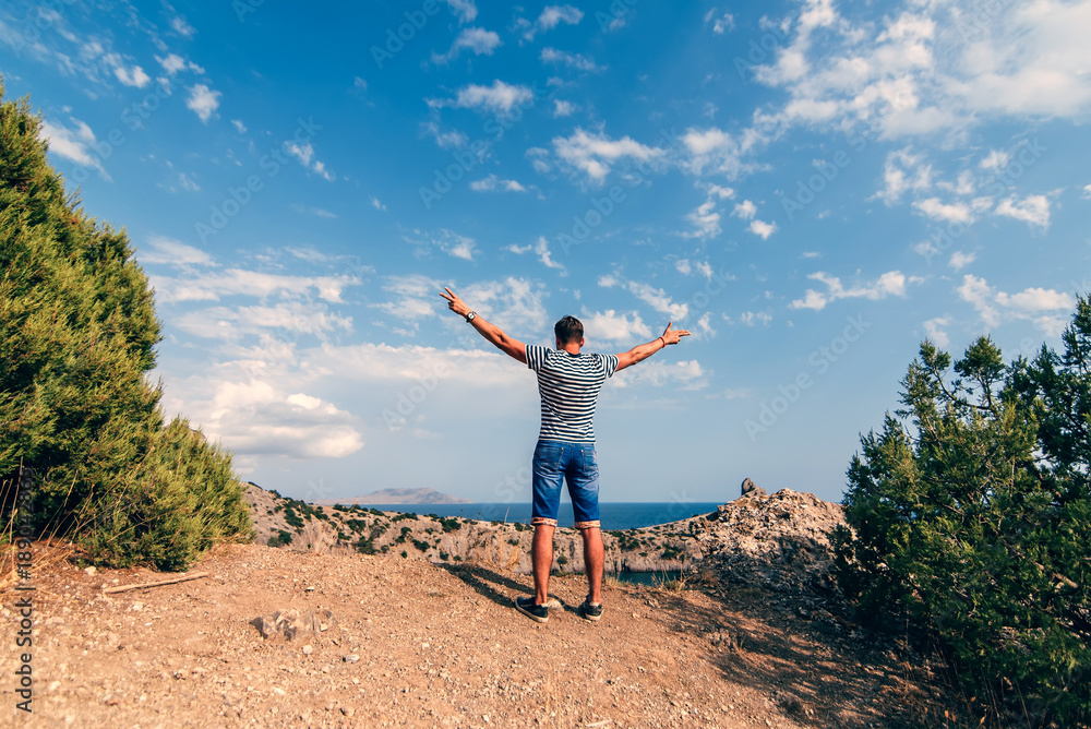 Fototapeta premium male traveler with arms raised to the sky