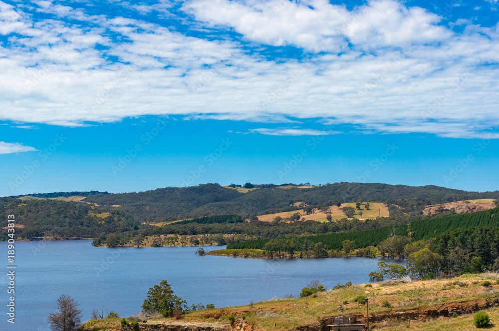 Australian landscape of lake, dam, and eucalyptus on hills