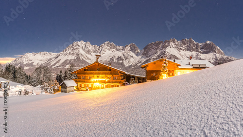 schön beleuchteter Bauernhof mit dem Wilden Kaiser im Hintergrund