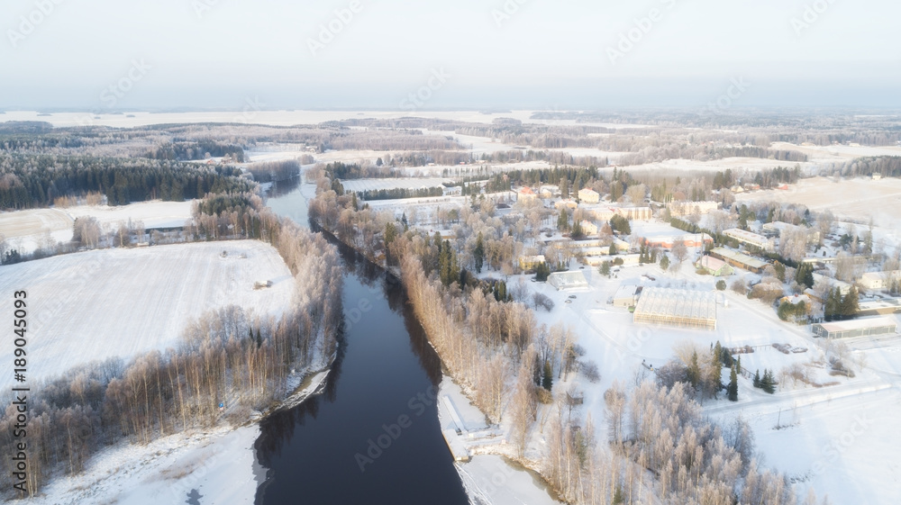 Countryside on snowy winter day. Aerial view of village and river at winter Countryside on snowy winter day. Aerial view of village and river at winter