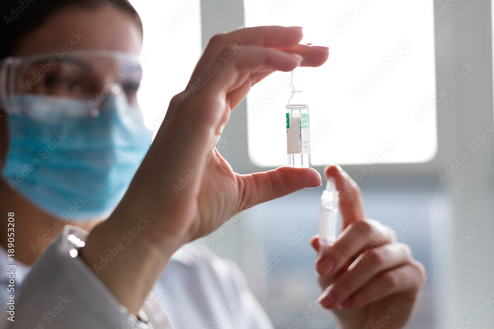 Woman laboratorian holding antibiotics samples and syringe Woman laboratorian holding antibiotics samples and syringe