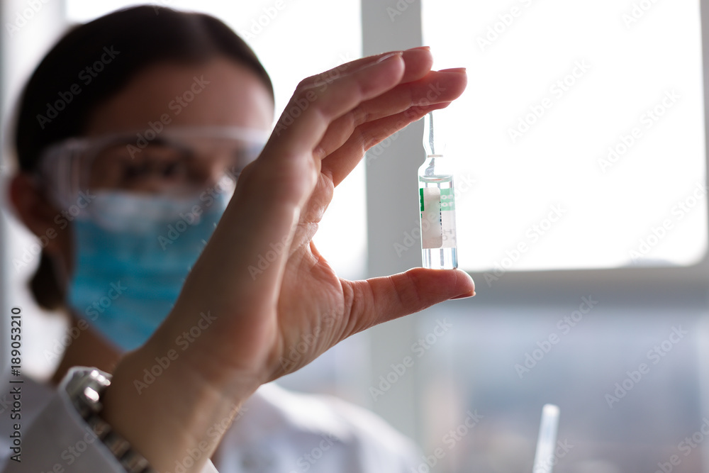 Woman laboratorian holding antibiotics samples and syringe Woman laboratorian holding antibiotics samples and syringe