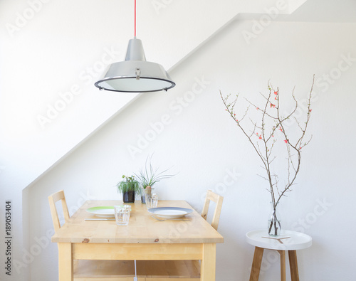Bright, modern kitchen with table, plates, glasses