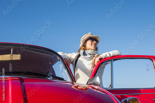 beautiful hippy vintage woman with old red car