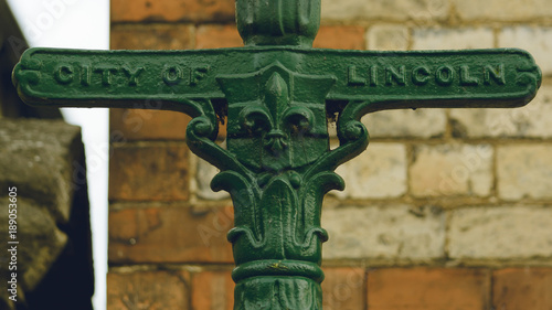 Close up of Old Lincoln Lamp Post, Blurred Wall in Background, Shallow Depth of Field Horizontal Photography