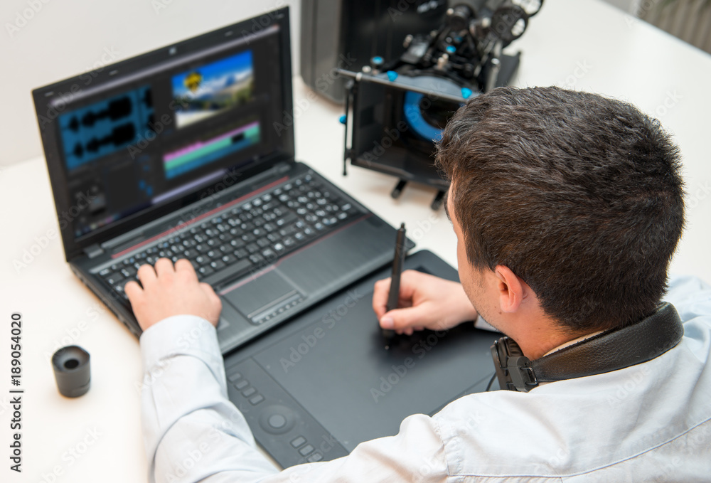 young man designer using graphics tablet for video editing young man designer using graphics tablet for video editing