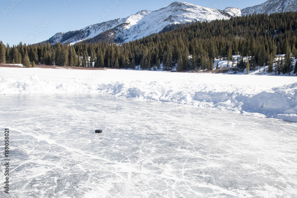 Puck on a small rink - Pond hockey on Andrew's lake in Colorado near Silverton Puck on a small rink - Pond hockey on Andrew's lake in Colorado near Silverton