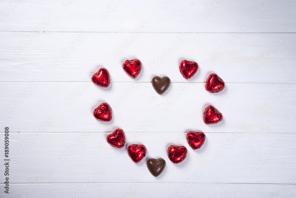 heart made of chocolates on white wooden background heart made of chocolates on white wooden background