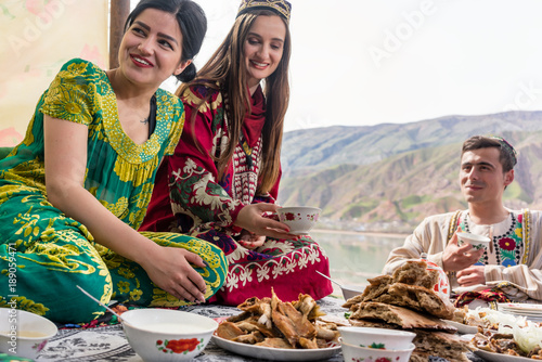 Friends in Tajikistan eating in traditional restaurant photo