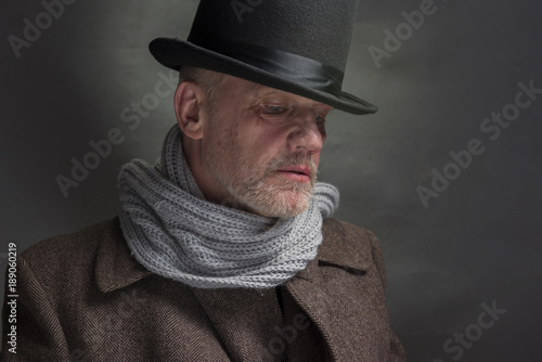 Photography Portrait of a sinister man wearing a top hat and a grey scarf