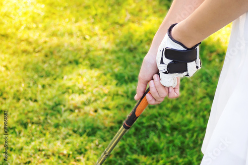 Closeup woman hand gripping golf club. Sport background with copy space.