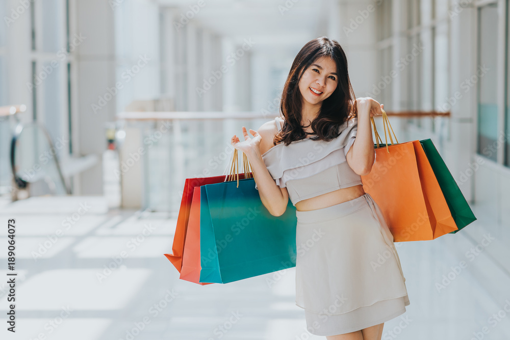 Happy Asian beautiful woman enjoying and smiling with colorful shopping bag in her both hand in mall. Happy Asian beautiful woman enjoying and smiling with colorful shopping bag in her both hand in mall.