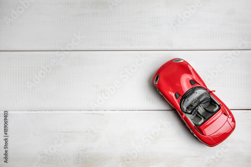 Small toy car on a white wooden background.